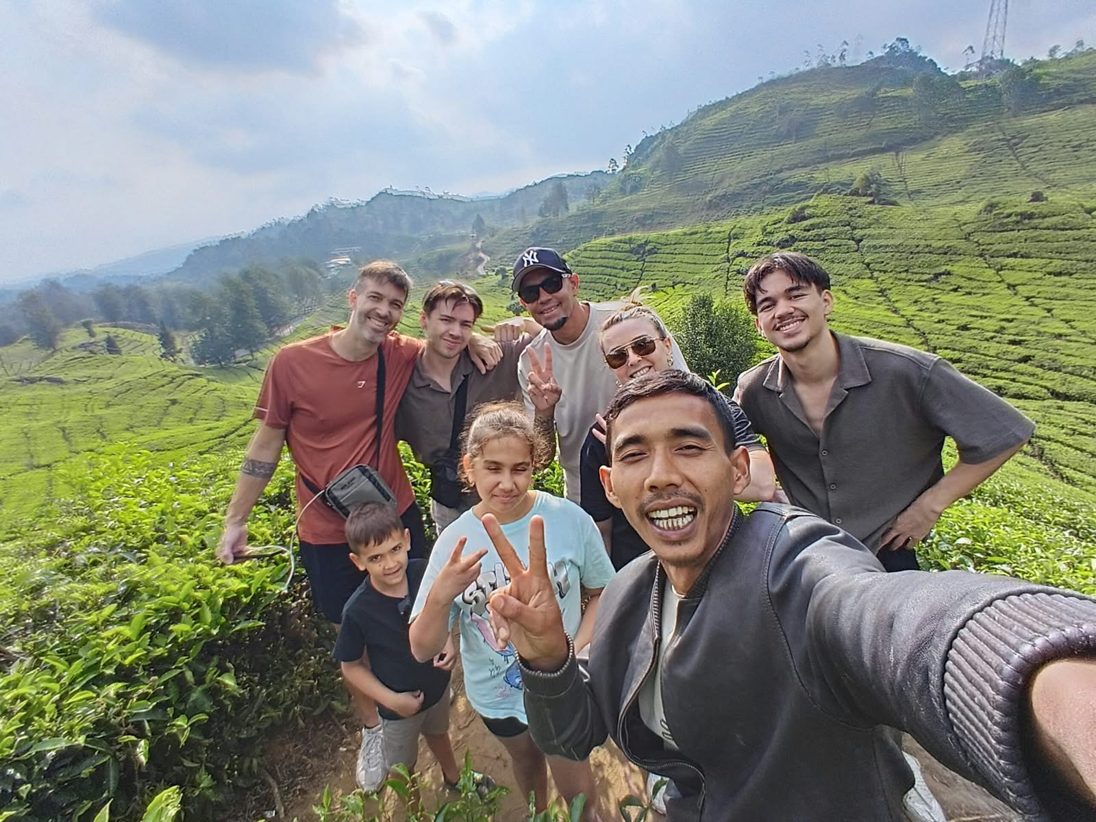 Group walking through emerald tea terraces